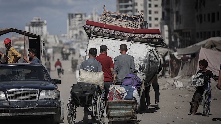 Warga Palestina berjalan ke utara di sepanjang Jalan al-Rashid menuju Kota Gaza, Gaza, Minggu (12/10/2025). (Ahmad Salem/Bloomberg)