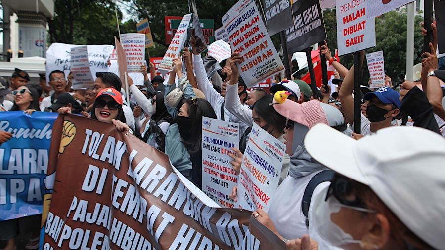Dalam aksinya pekerja dan pengusaha tenpat hiburan membawa berbagai macam poster tuntutan. (Bloomberg Technoz/Andrean Kristianto)
