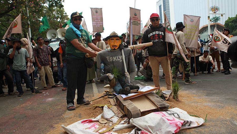 Dalam aksinya massa membawa boneka berbentuk petani sebagai simbol nasib petani kecil yang tertekan. (Bloomberg Technoz/Andrean Kristianto)