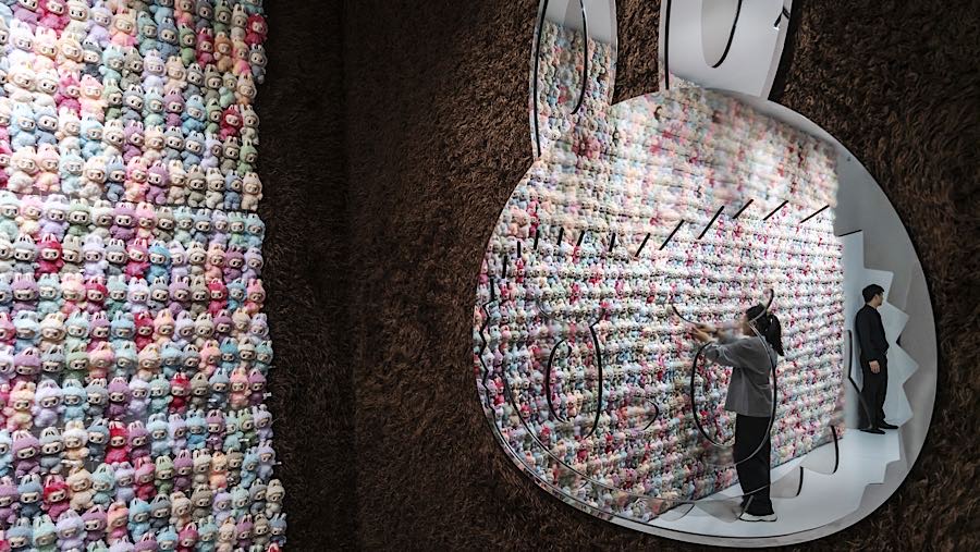 Pengunjung di depan dinding boneka Labubu saat pameran ulang tahun ke-10 Pop Mart di Shanghai, China, Rabu (15/10/2025). (Qilai Shen/Bloomberg)
