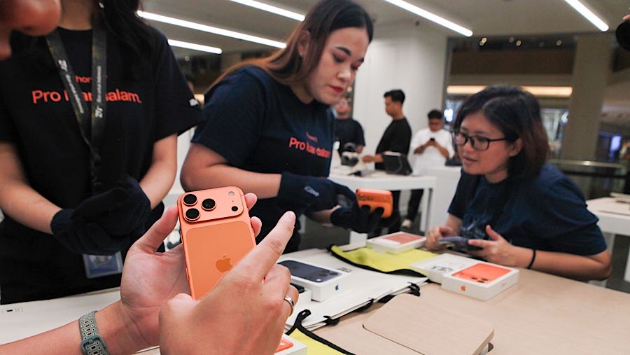 Karyawan membantu pembeli untuk memeiksa unit iPhone 17 Series di iBox Gandaria City, Jumat (17/10/2025). (Bloomberg Technoz/Andrean Kristianto)
