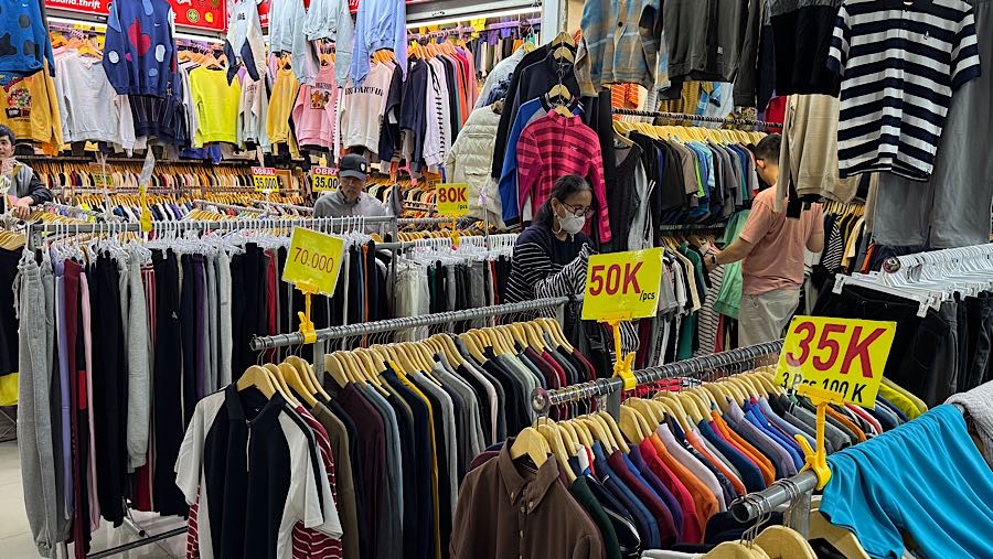 Colon pembeli melihat baju thrift (pakaian bekas impor) di Pasar Jaya Senen, Jakarta, Kamis (23/10/2025). (Bloomberg Technoz/Andrean Kristianto)