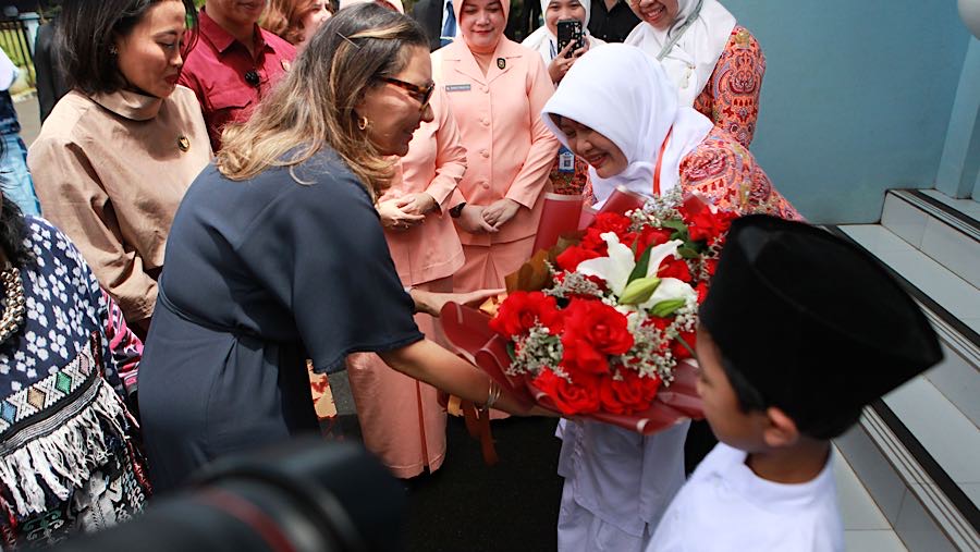 Usai dari SPPG Janja menuju SD Angkasa 5 Halim dan disambut dua siswa yang memberikan bunga. (Bloomberg Technoz/Andrean Kristianto)