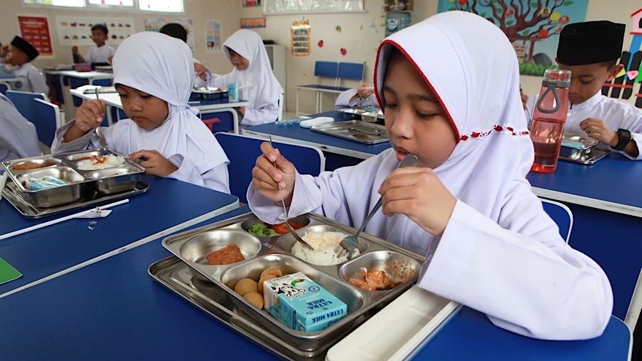 Siswa menyantap Makan Bergizi Gratis (MBG) di SD Angkasa 5 Halim, Jakarta Timur, Jumat (23/10/2025). (Bloomberg Technoz/Andrean Kristianto)
