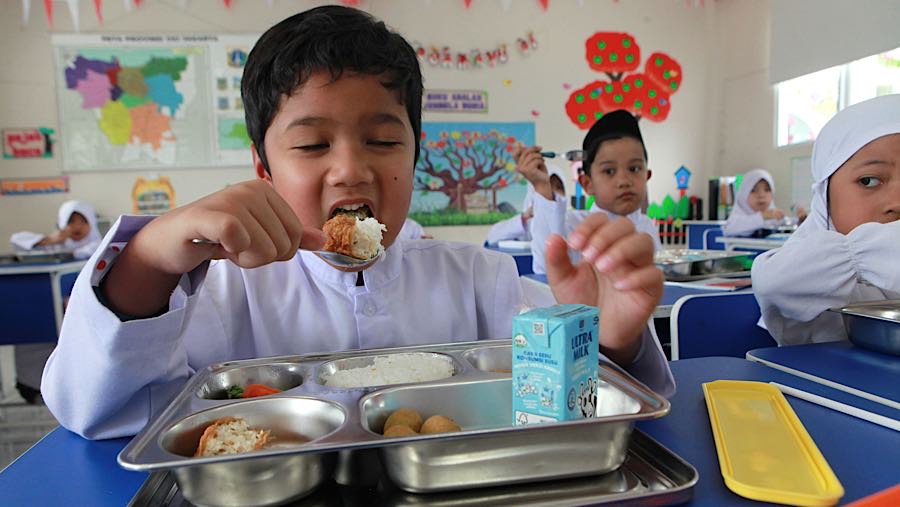Siswa menyantap Makan Bergizi Gratis (MBG) di SD Angkasa 5 Halim, Jakarta Timur, Jumat (23/10/2025). (Bloomberg Technoz/Andrean Kristianto)
