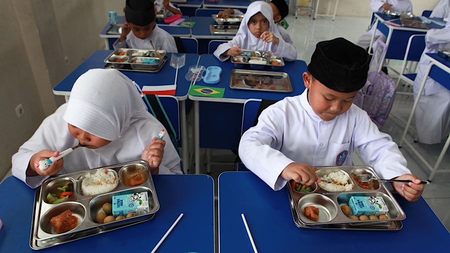 Siswa menyantap Makan Bergizi Gratis (MBG) di SD Angkasa 5 Halim, Jakarta Timur, Jumat (23/10/2025). (Bloomberg Technoz/Andrean Kristianto)