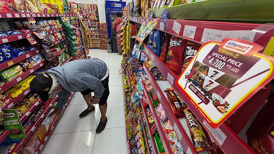 Pengunjung melihat produk yang dijual di Alfamart Pamulang, Tangerang Selatan, Kamis (30/10/2025). (Bloomberg Technoz/Andrean Kristianto)