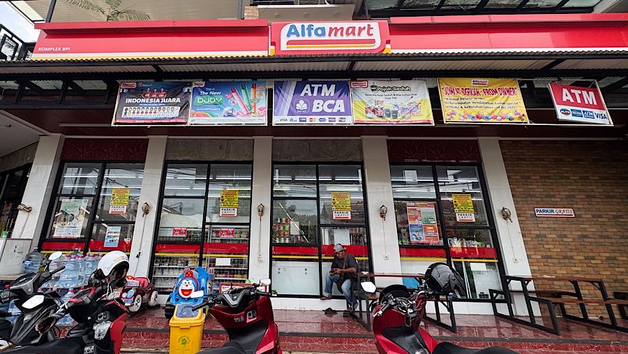 Sejunlah kendaraan terparkir di depan Alfamart Pamulang, Tangerang Selatan, Kamis (30/10/2025). (Bloomberg Technoz/Andrean Kristianto)