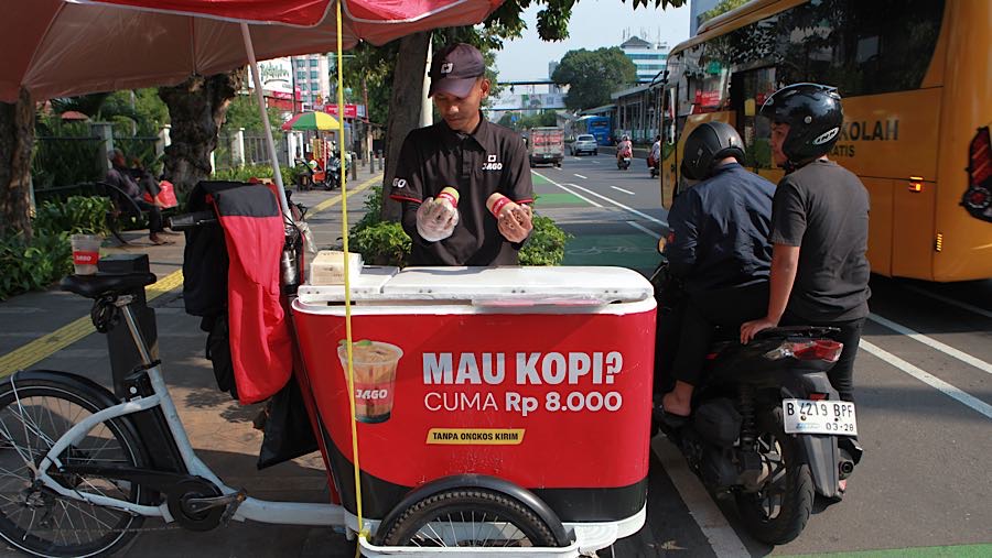 Penjual kopi gerobak keliling melayani pembeli di kawasan Salemba, Jakarta Pusat, Jumat (31/10/2025). (Bloomberg Technoz/Andrean Kristianto)