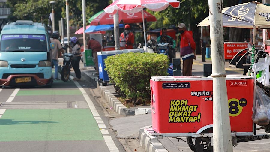 Penjual kopi gerobak keliling menunggu pembeli di kawasan Salemba, Jakarta, Jumat (31/10/2025). (Bloomberg Technoz/Andrean Kristianto)