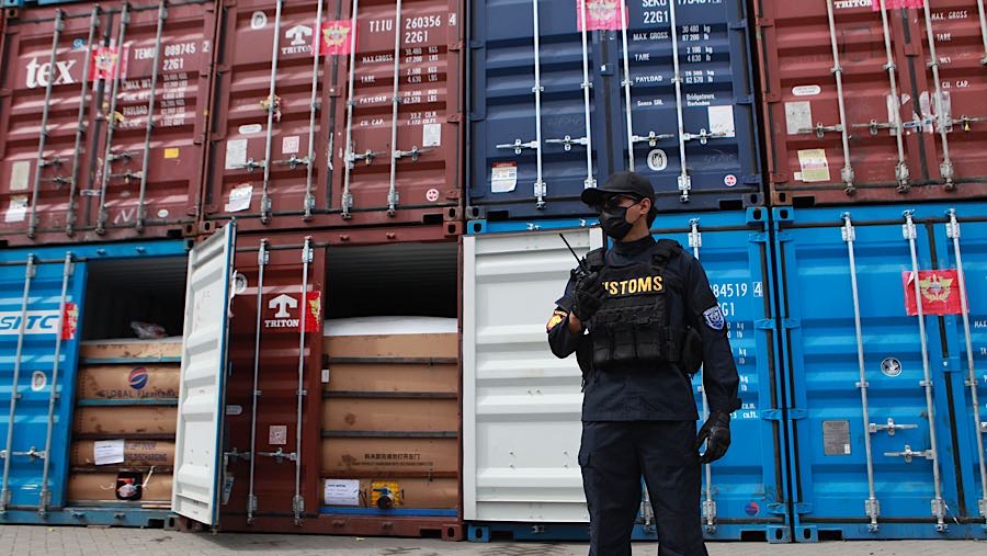 Petugas di depan kontainer yang melanggar ekspor turunan minyak sawit mentah (CPO) di Terminal Kalibaru, Kamis (6/11/2025) (Bloomberg Technoz/Andrean)