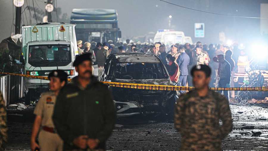 Petugas keamanan di dekat kendaraan yang hancur di lokasi ledakan di New Delhi, India (10/11/2025). (Prakash Singh/Bloomberg)