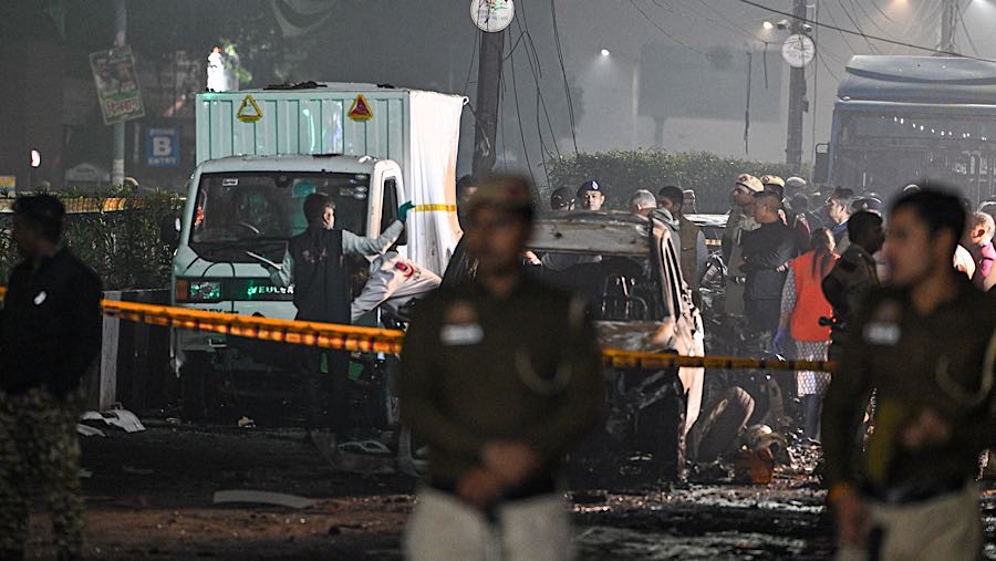 Warga berlarian di sekitar kendaraan yang hancur dan terbakar, dengan pecahan kaca serta puing berserakan di jalan. (Prakash Singh/Bloomberg)