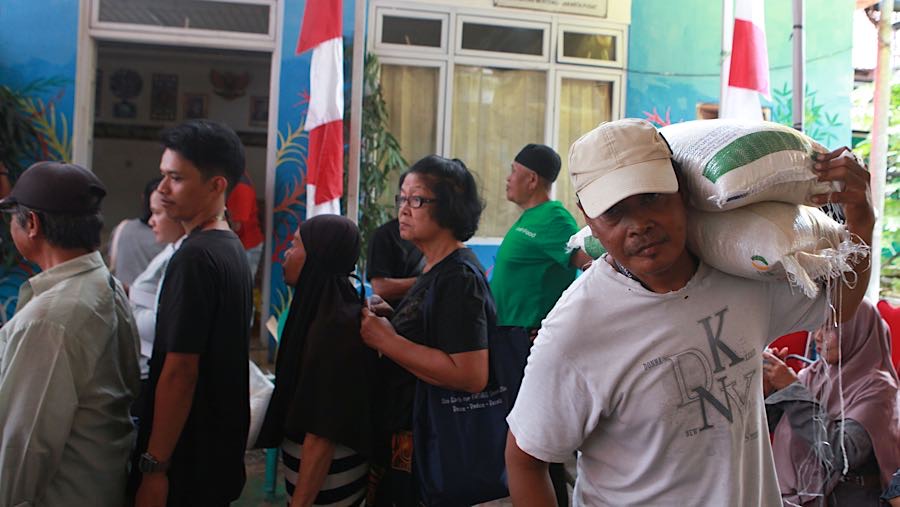 Warga membawa beras bantuan pangan di Sekretariat RW 03 Menteng, Jakarta, Rabu (12/11/2025). (Bloomberg Technoz/Andrean Kristianto)