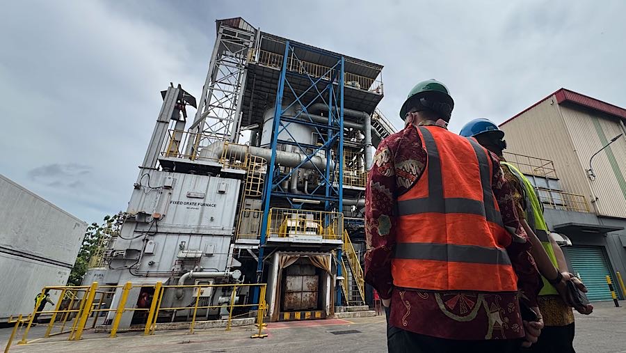 Dua orang melihat mesin pembakaran balpres pakaian bekas yang dimusnahkan di PT PPLI, Bogor, Jumat (14/11/2025) (Bloomberg Technoz/Andrean Kristianto)
