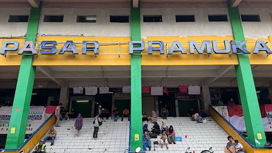 Warga duduk di tangga Pasar Pramuka, Matraman, Jakarta, Jumat (14/11/2025). (Bloomberg Technoz/Andrean Kristianto)