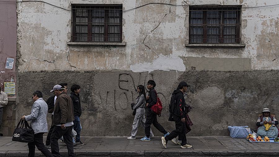 Warga di depan coretan dinding bertuliskan nama mantan Presiden Evo Morales di La Paz, Bolivia, Rabu (12/11/2025). (Marcelo Perez Del Carpio/Bloomberg
