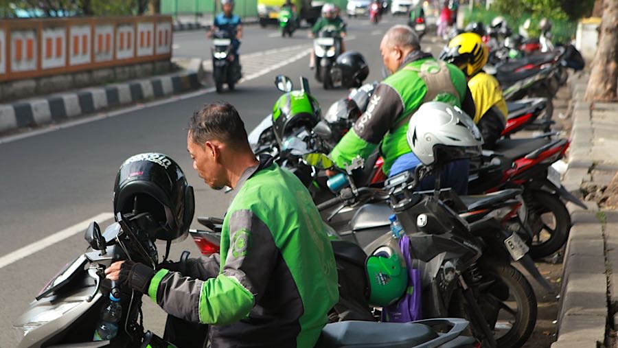 Pengemudi ojek online (ojol) menunggu penumpang di Stasiun Pasar Minggu, Jakarta, Senin (24/11/2025). (Bloomberg Technoz/Andrean Kristianto)