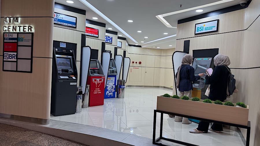 Warga mengambil uang tunai dari mesin ATM di Jakarta, Senin (24/11/2025). (Bloomberg Technoz/Andrean Kristianto)
