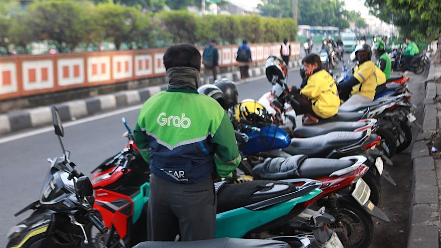 Pengemudi ojek online (ojol) menunggu penumpang di Stasiun Pasar Minggu, Jakarta, Rabu (26/11/2025). (Bloomberg Technoz/Andrean Kristianto)