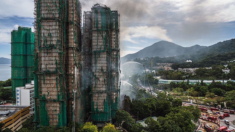 Asap mengepul dari bangunan-bangunan perumahan yang terbakar di Wang Fuk Court, distrik Tai Po, Hong Kong, Kamis (27/11/2025). (Lam Yik/Bloomberg)