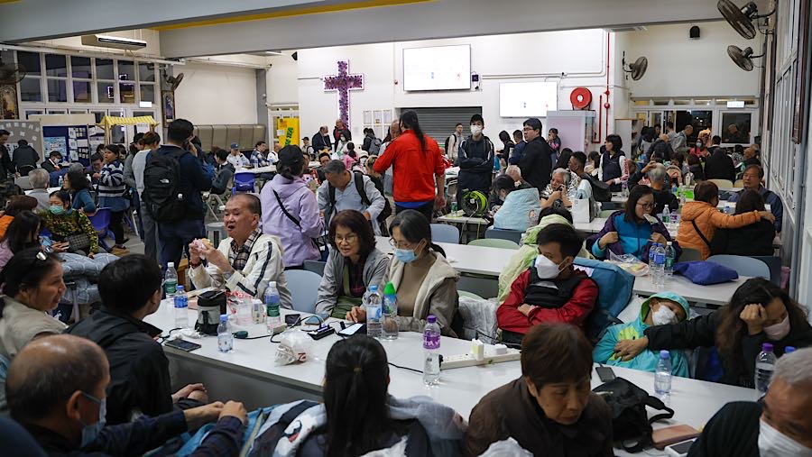 Warga mengungsi setelah kebakaran di kompleks perumahan Wang Fuk Court di distrik Tai Po, Hong Kong, Rabu (26/11/2025). (Yik Yeung-man/Bloomberg)