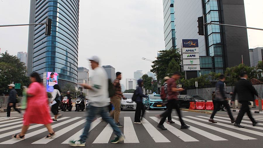 Warga menyeberang jalan di jalan Sudirman, Jakarta, Kamis (27/11/2025). (Bloomberg Technoz/Andrean Kristianto)
