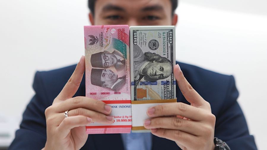 Karyawan memperlihatkan uang rupiah dan dolas AS di salah satu bank di Jakarta, Senin (1/12/2025). (Bloomberg Technoz/Andrean Kristianto)