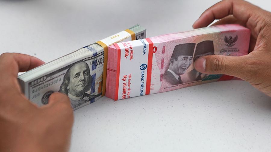 Karyawan merapihkan uang rupiah dan dolas AS di salah satu bank di Jakarta, Senin (1/12/2025). (Bloomberg Technoz/Andrean Kristianto)