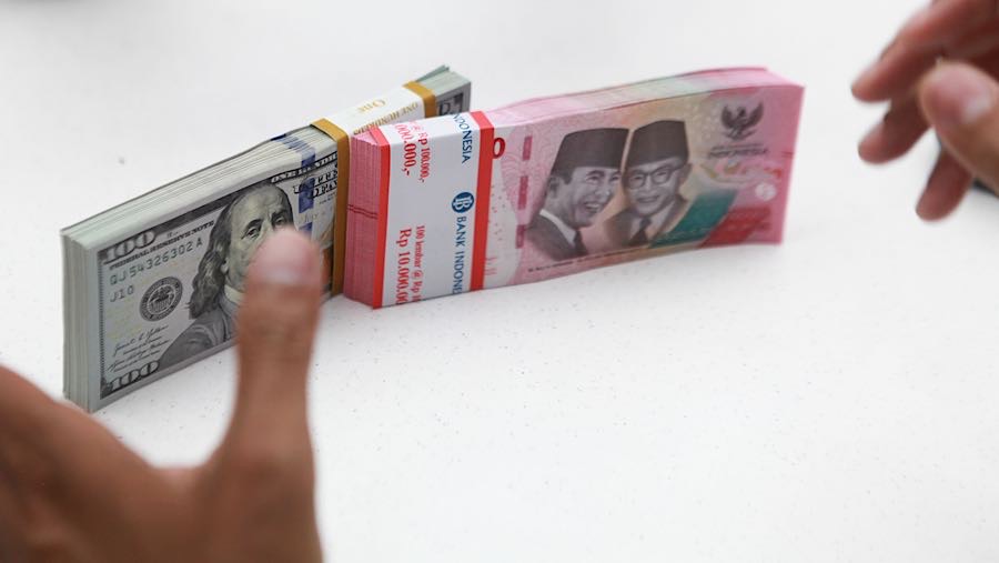 Karyawan merapihkan uang rupiah dan dolas AS di salah satu bank di Jakarta, Senin (1/12/2025). (Bloomberg Technoz/Andrean Kristianto)
