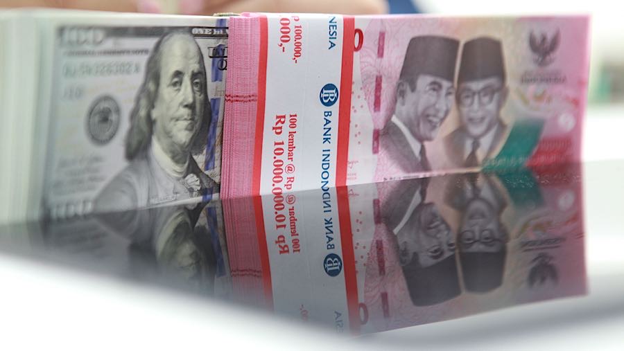 Karyawan merapihkan uang rupiah dan dolas AS di salah satu bank di Jakarta, Senin (1/12/2025). (Bloomberg Technoz/Andrean Kristianto)
