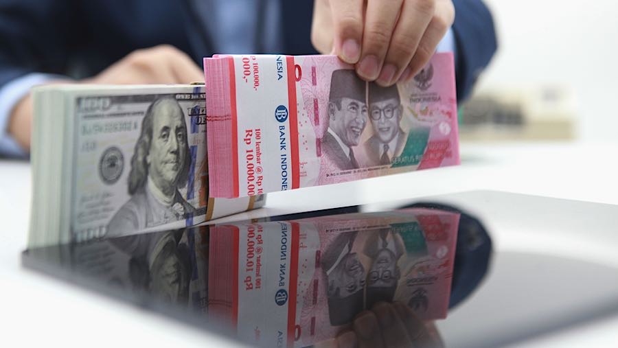 Karyawan merapihkan uang rupiah dan dolas AS di salah satu bank di Jakarta, Senin (1/12/2025). (Bloomberg Technoz/Andrean Kristianto)