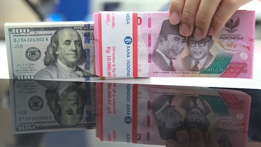 Karyawan merapihkan uang rupiah dan dolas AS di salah satu bank di Jakarta, Senin (1/12/2025). (Bloomberg Technoz/Andrean Kristianto)
