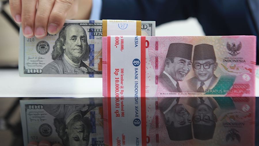 Karyawan merapihkan uang rupiah dan dolas AS di salah satu bank di Jakarta, Senin (1/12/2025). (Bloomberg Technoz/Andrean Kristianto)