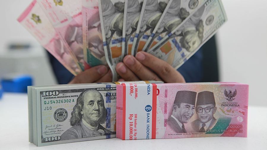 Karyawan merapihkan uang rupiah dan dolas AS di salah satu bank di Jakarta, Senin (1/12/2025). (Bloomberg Technoz/Andrean Kristianto)
