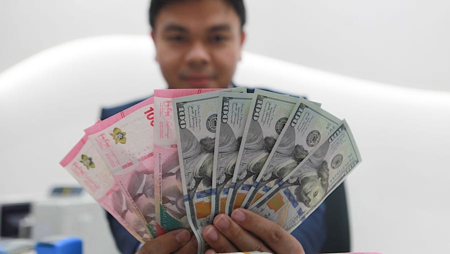 Karyawan merapihkan uang rupiah dan dolas AS di salah satu bank di Jakarta, Senin (1/12/2025). (Bloomberg Technoz/Andrean Kristianto)
