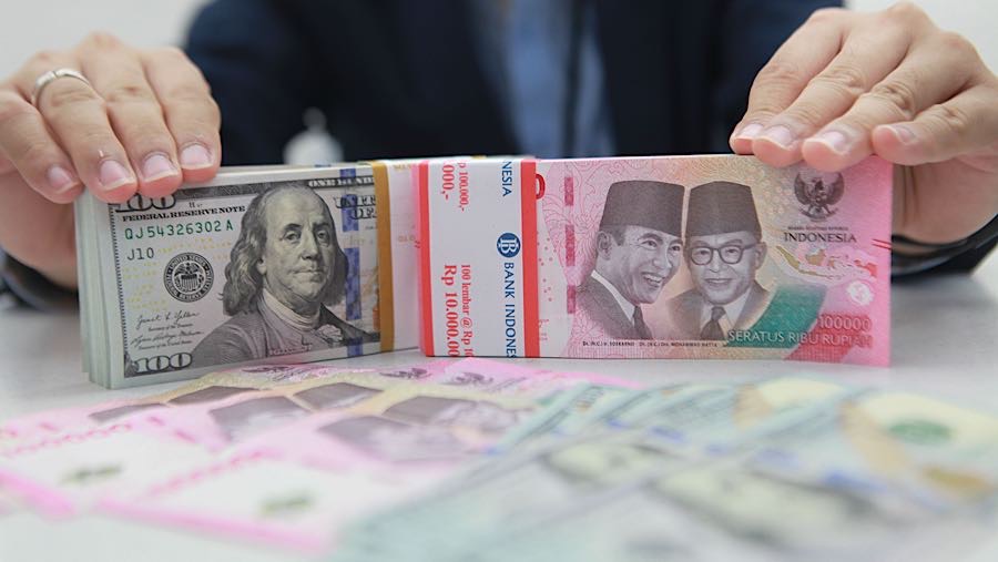 Karyawan merapihkan uang rupiah dan dolas AS di salah satu bank di Jakarta, Senin (1/12/2025). (Bloomberg Technoz/Andrean Kristianto)
