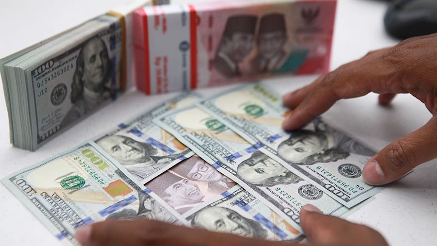 Karyawan merapihkan uang rupiah dan dolas AS di salah satu bank di Jakarta, Senin (1/12/2025). (Bloomberg Technoz/Andrean Kristianto)
