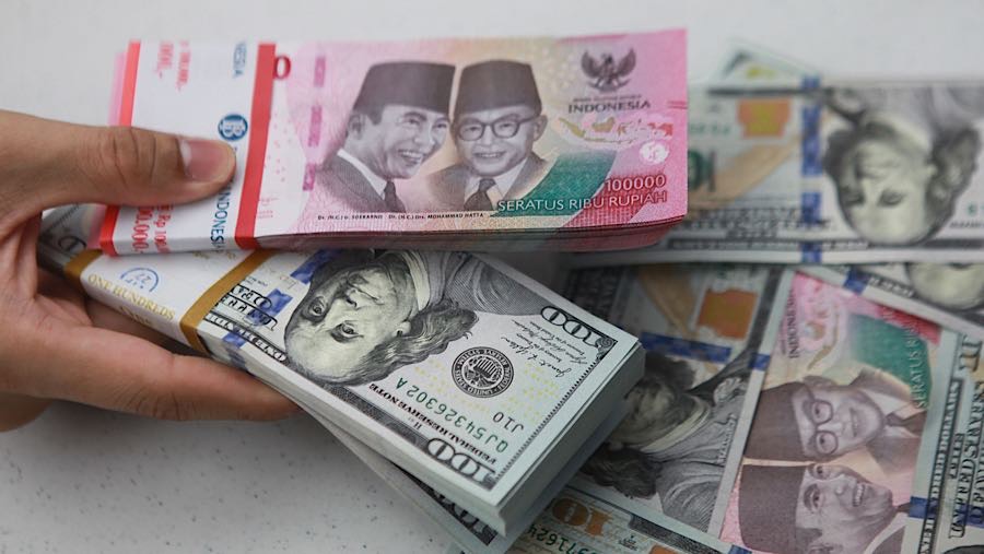 Karyawan merapihkan uang rupiah dan dolas AS di salah satu bank di Jakarta, Senin (1/12/2025). (Bloomberg Technoz/Andrean Kristianto)
