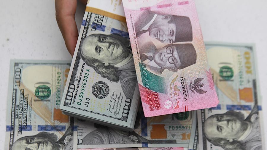 Karyawan merapihkan uang rupiah dan dolas AS di salah satu bank di Jakarta, Senin (1/12/2025). (Bloomberg Technoz/Andrean Kristianto)
