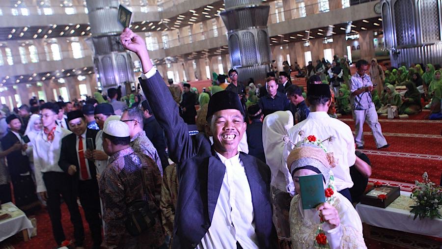 Senyum bahagia terpancar dari mereka yang telah sah melangsungkan pernikahan. (Bloomberg Technoz/ Andrean Kristianto)