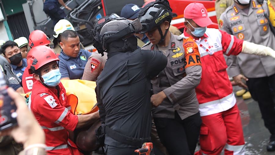 Petugas mengevakuasi korban kebakaran di perkantoran Terra Drone, Cempaka Baru, Jakarta, Selasa (9/12/2025). (Bloomberg Technoz/Andrean Kristianto)