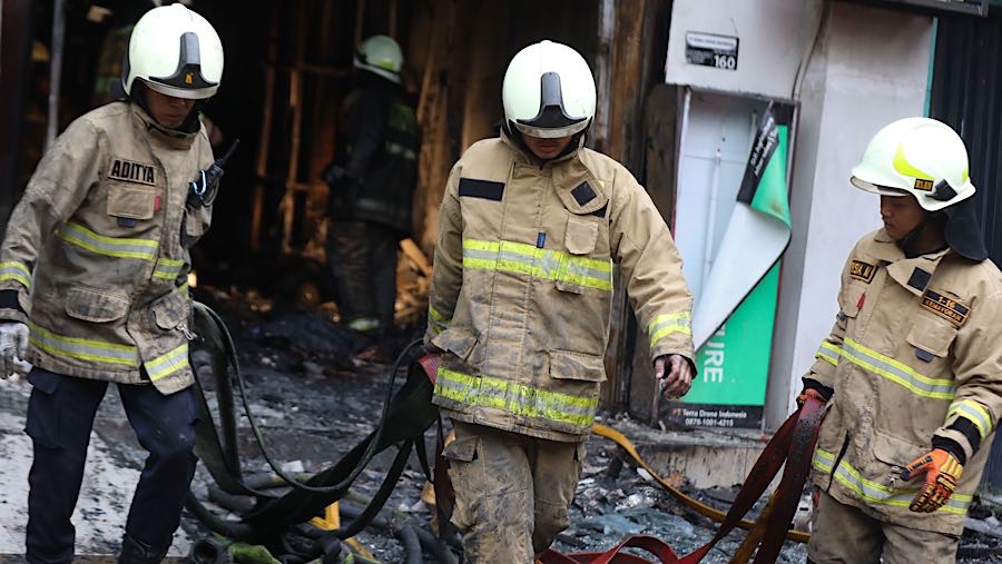 Petugas usai memadamkan api saat kebakaran ruko di Cempaka Baru, Jakarta, Selasa (9/12/2025). (Bloomberg Technoz/Andrean Kristianto)