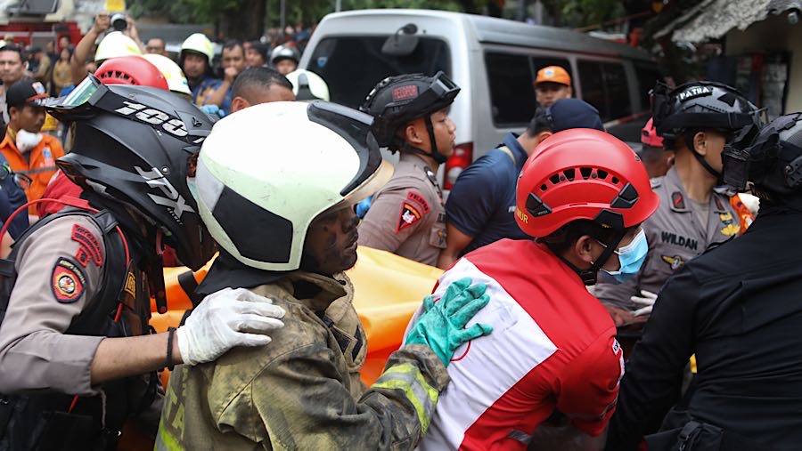 Petugas mengevakuasi korban kebakaran di perkantoran Terra Drone, Cempaka Baru, Jakarta, Selasa (9/12/2025). (Bloomberg Technoz/Andrean Kristianto)