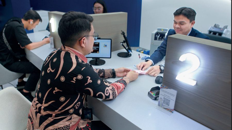 Aktivitas nasabah bertransaksi di teller perbankan. 