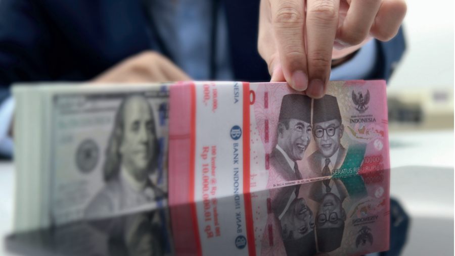Uang dolar AS dan rupiah ditunjukkan oleh pegawai bank