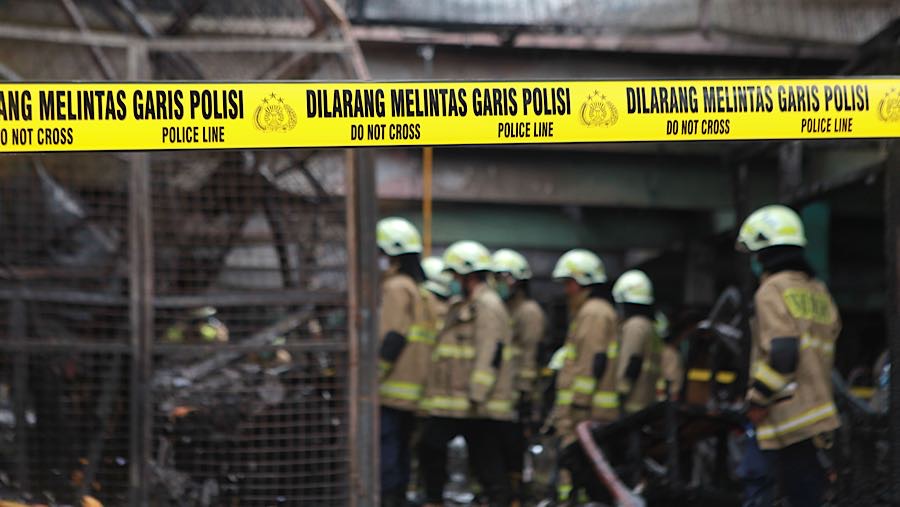 Petugas melakukan proses pendinginan saat kebakaran di Pasar Induk Kramat Jati, Senin (15/12/2025). (Bloomberg Technoz/Andrean Kristianto)