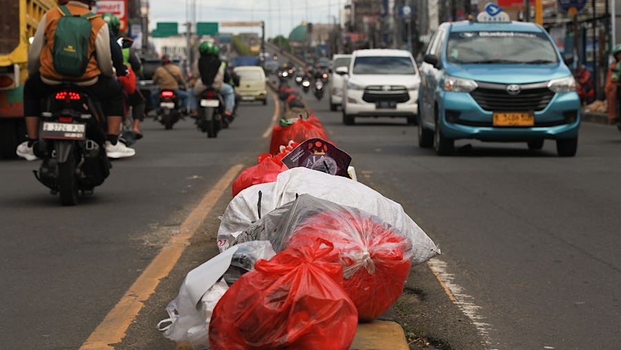 Sampah terlihat juga berjejer diatas trotoar di Jln. Dewi Sartika, Tangerang Selatan. (Bloomberg Technoz/Andrean Kristianto)