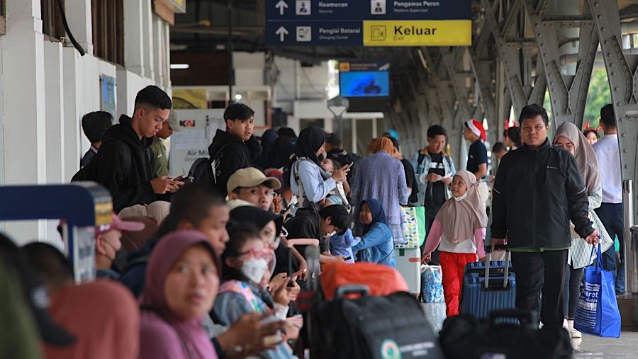 Penumpang memasuki peron keberangkatan kereta api jarak jauh di Stasiun Pasar Senen, Senin (22/12/2025). (Bloomberg Technoz/Andrean Kristianto)