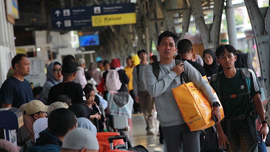 Penumpang memasuki peron keberangkatan kereta api jarak jauh di Stasiun Pasar Senen, Senin (22/12/2025). (Bloomberg Technoz/Andrean Kristianto)